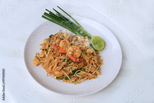 Thai style noodles, Pad Thai, stir-fried rice noodles with shrimp serve with vegetable in white plate on white background. The one of Thailand's national main dish. the popular food in Thailand.