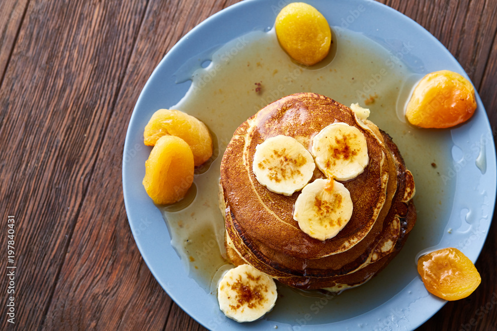 Pile of homemade pancakes with honey and walnuts on rustic wooden background, selective focus Pile of homemade pancakes with honey and walnuts on rustic wooden background, selective focus