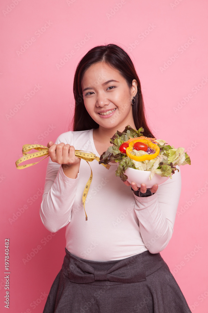 Healthy Asian woman with measuring tape and salad. Healthy Asian woman with measuring tape and salad.