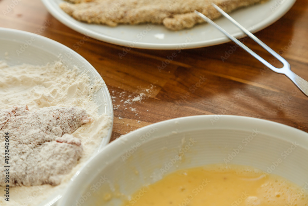 Panieren eines Schweineschnitzels