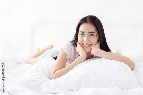 Beautiful Asian Woman wake up on bed with happy emotion. People lifestyle concept.