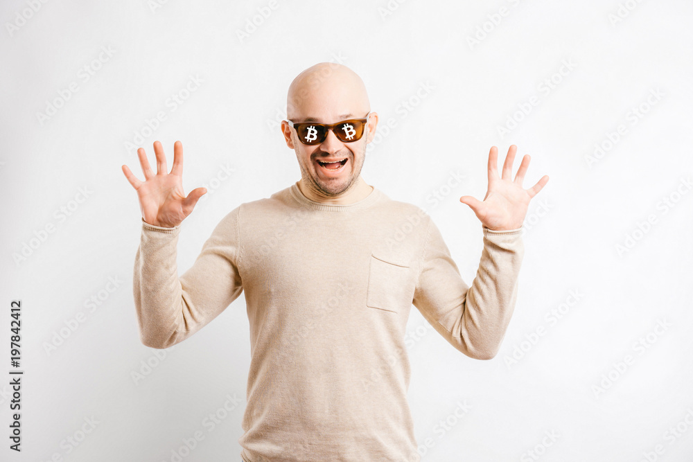 Naklejka premium Happy bald businessman with cryptocurrency bitcoin signs on sunglasses. Excited unusual man financial forecast. Successful trader expressive face. Funny blockchain miner portrait isolated on white.