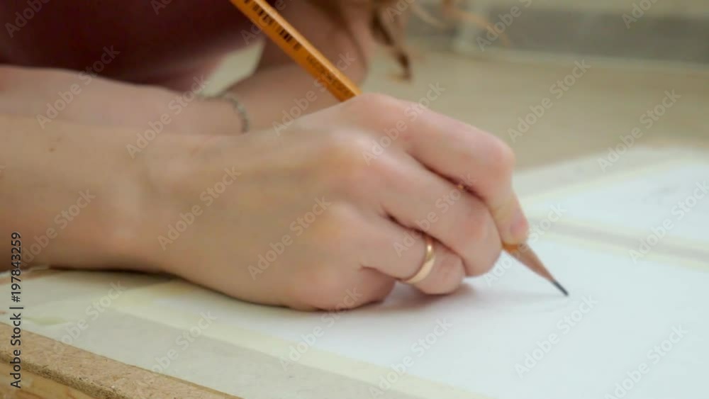 young woman lying on the floor and draws a pencil on the tablet young woman lying on the floor and draws a pencil on the tablet