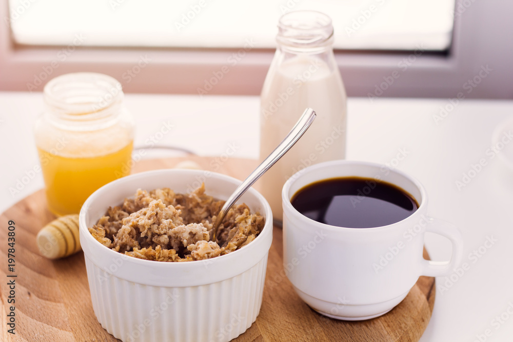 healthy breakfast fresh cereal, milk bottle, coffee cup and honey jar sunny warm toned healthy breakfast fresh cereal, milk bottle, coffee cup and honey jar sunny warm toned