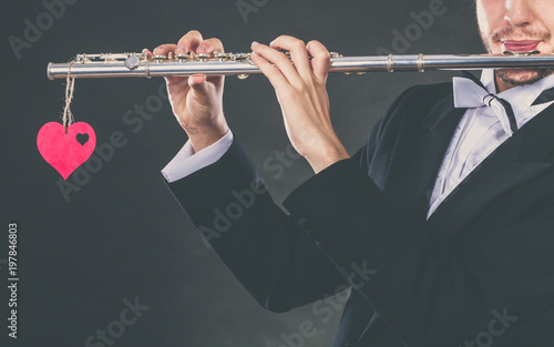 Male flutist with flute and heart. Love melody