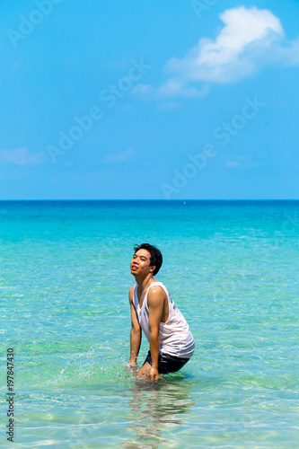 The man is fun and enjoy swimmimg or playing in the clear sea and blue sky background inthe sunny day  Thailand.