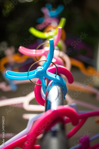 Colorful clothes Hangers and Clothes pegs  hanged on metal rack outdoor, Close up