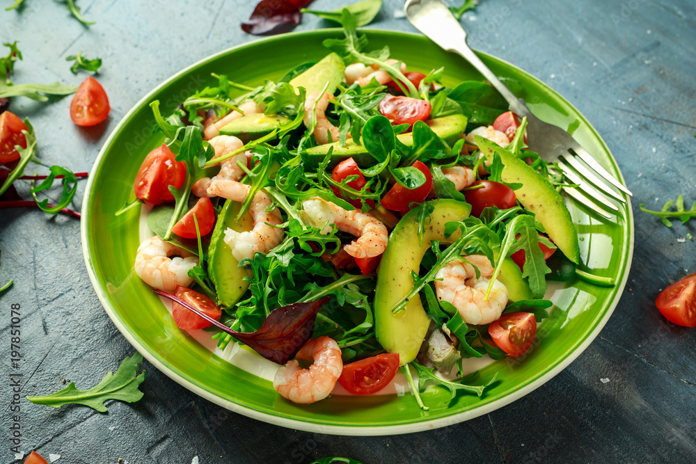 Fresh Avocado, shrimps salad with lettuce green mix, cherry tomatoes, herbs and olive oil, lemon dressing. healthy food Fresh Avocado, shrimps salad with lettuce green mix, cherry tomatoes, herbs and olive oil, lemon dressing. healthy food