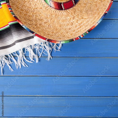 Mexico cinco de mayo background border square format with sombrero straw hat traditional rug or blanket on an old blue wood background fiesta carnival photo