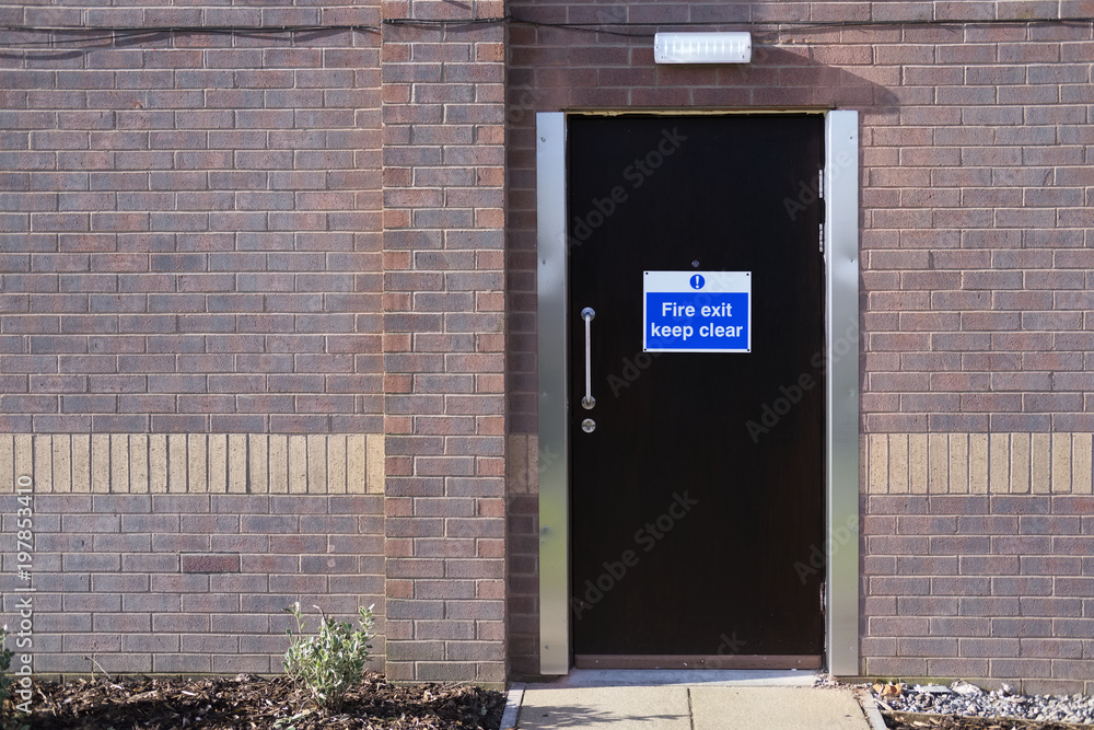 Naklejka premium Fire exit emergency keep clear sign on hotel door for safety of workers guests people