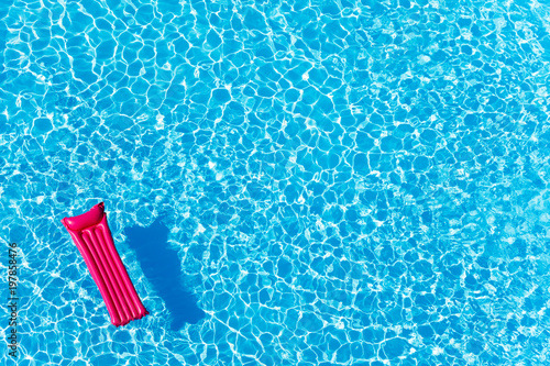 Pink inflatable mattress floating on water surface