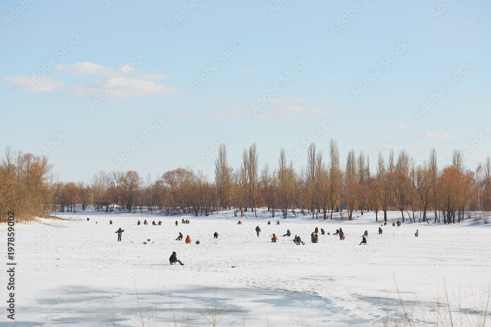 GOMEL, Belarus - MARCH 24, 2018: Winter fishing. Fishermen on the ice catch fish.