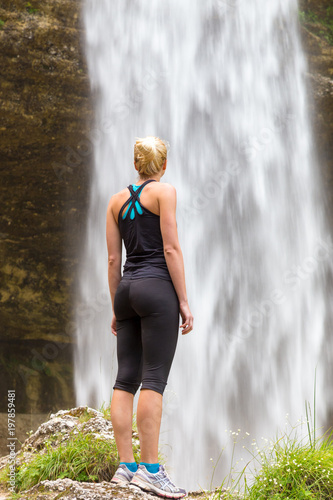 Active woman enjoying beautiful natural environment under Pericnik waterfall in Vrata Valley in Triglav National Park in Julian Alps, Slovenia. photo