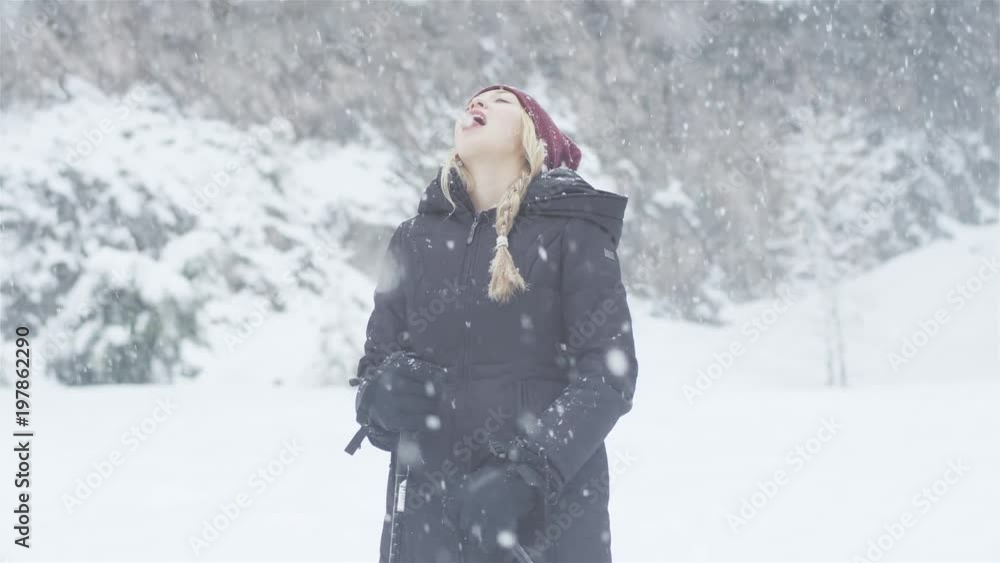 Beautiful young Asian woman trying to catch some snow flakes with her tongue Beautiful young Asian woman trying to catch some snow flakes with her tongue