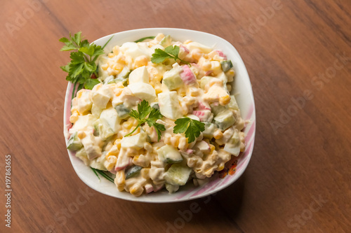 Salad with crab sticks, sweet corn, cucumber, eggs and mayonnaise