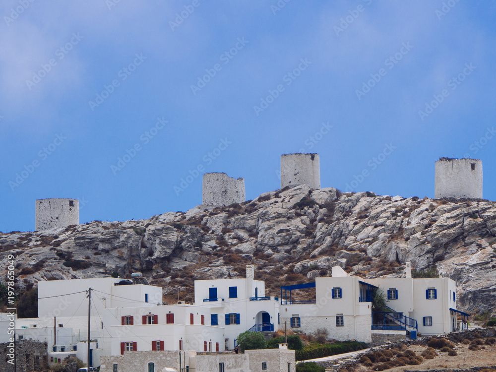 A view of some white houses of Chora of Amorgos, with the windmills above them