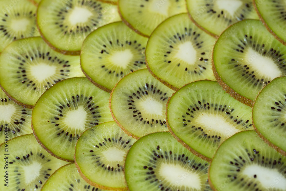 Bright green background with slices of juicy kiwi. Healthy food background. Bright green background with slices of juicy kiwi. Healthy food background.