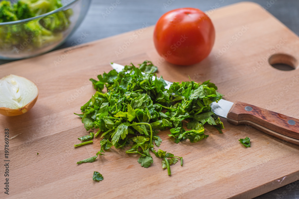 Sliced parsley and vegetables on a wooden cutting board Sliced parsley and vegetables on a wooden cutting board
