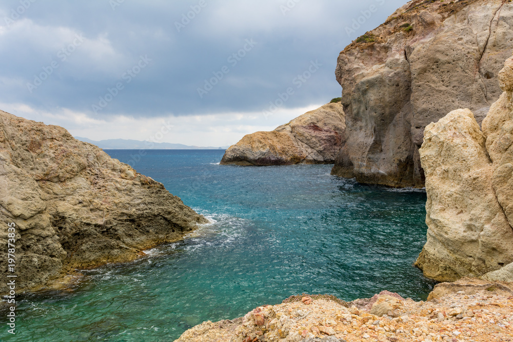 Rocks and emerald sea water in Firopotamos Bay on Milos, Cyclades Islands, Greece.