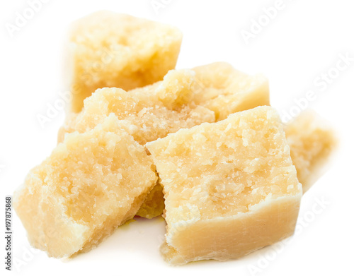 Heap of parmesan cheese pieces isolated on white background, close up
