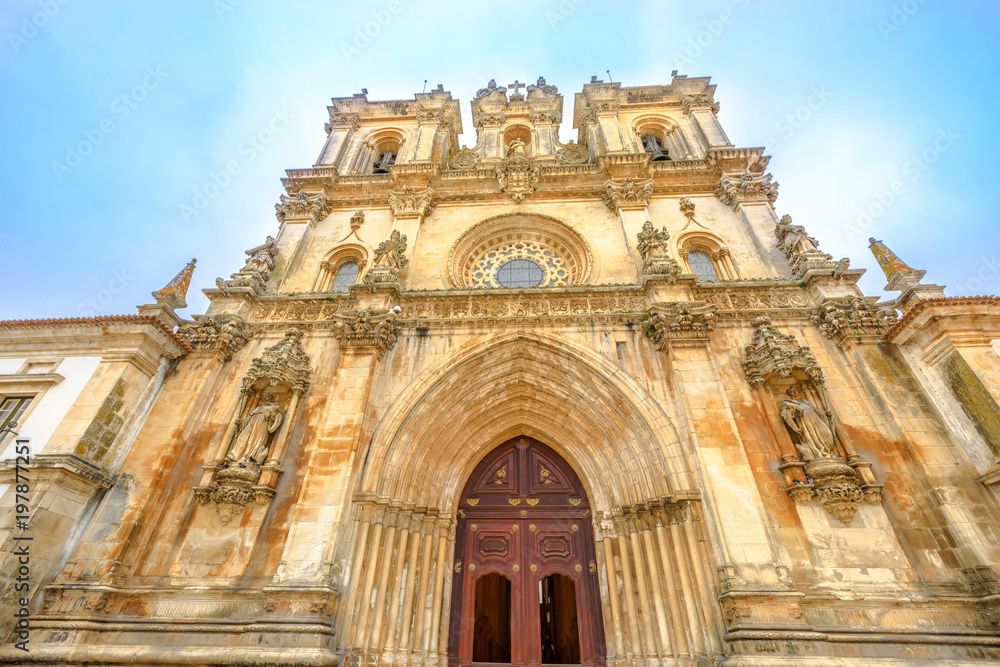 Bottom view of main gate of Roman Gothic Monastery of Alcobaca or Mosteiro de Santa Maria de Alcobaca, Unesco Heritage in Alcobaca. The church and covent were the first Gothic building in Portugal. Bottom view of main gate of Roman Gothic Monastery of Alcobaca or Mosteiro de Santa Maria de Alcobaca, Unesco Heritage in Alcobaca. The church and covent were the first Gothic building in Portugal.