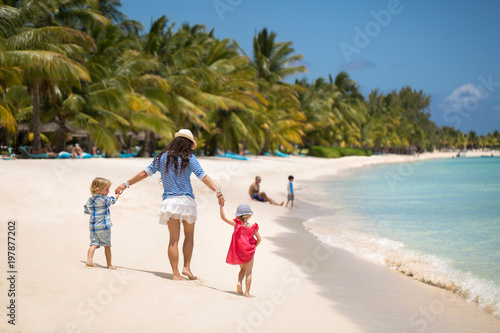 Beautiful mother  son and daughter walking on the beach of the Indian ocean.
