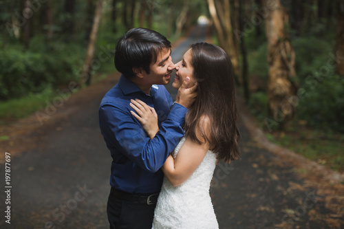 bride and groom newlyweds kissing in woods on green background Wedding Day