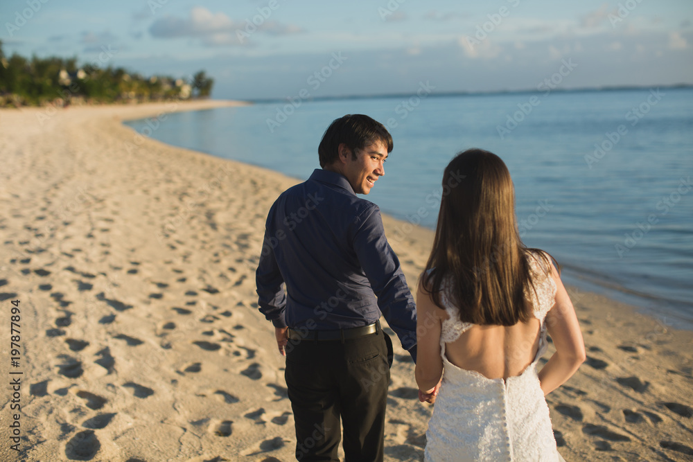 bride and groom walking on the beach of Mauritius bride and groom walking on the beach of Mauritius