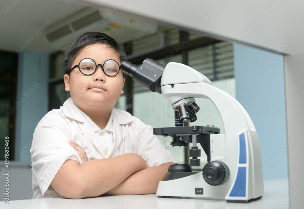smart boy working with microscope in laboratory smart boy working with microscope in laboratory