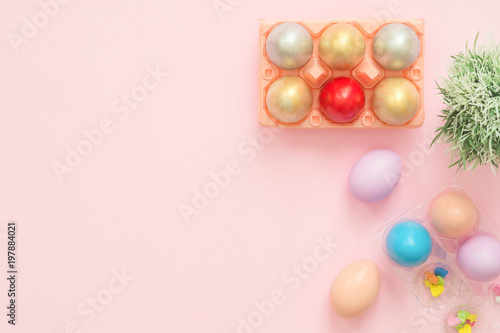 Flat lay top view colorful easter egg painted in pastel colors composition and spring flowers on pink pastel color background. Easter day background top view with copy space. © tirachard