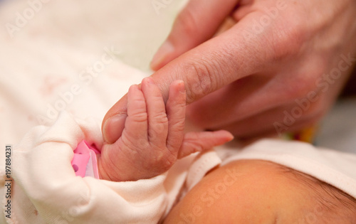The baby clings to his father's finger