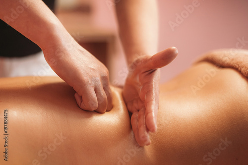 a masseur doing massage of back by hands