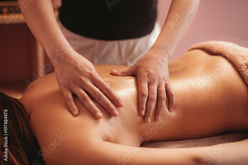 a masseur doing massage of back for girl