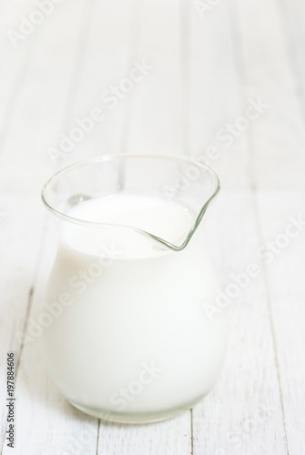 Milk jug on white wooden table