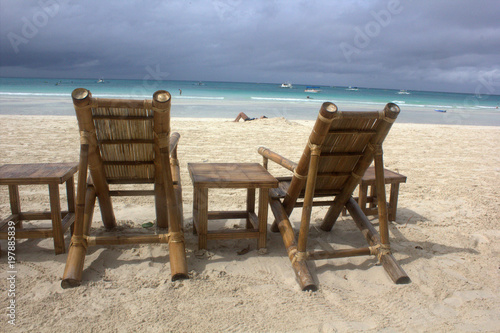 chaise lounges on sand by the sea