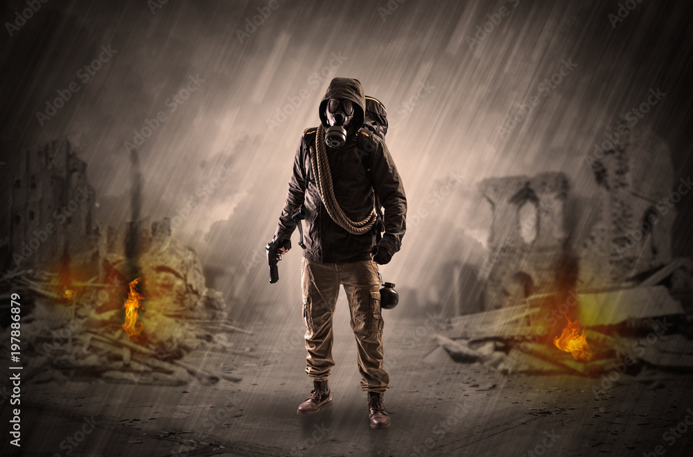 Fototapeta premium Destroyed place after a catastrophe with man in gas mask and weapon on his hand 