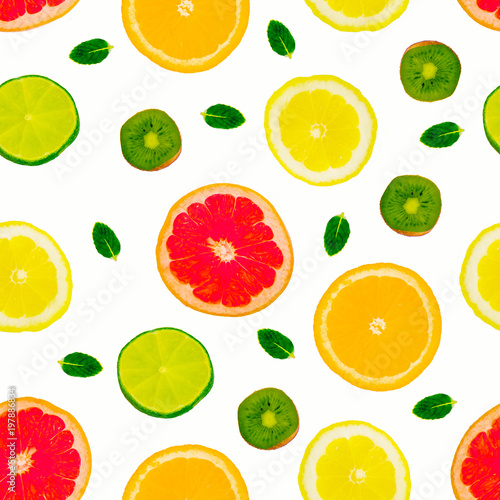 Fruity summer refreshing pattern. White isolated background. Orange slices, lemon, lime, kiwi and grapeprut and mint leaves. View from above. For textiles, wrappers, postcards, printed products.