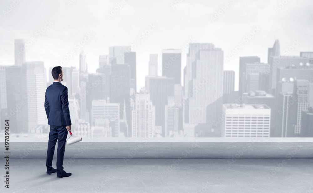 Businessman standing with his back on a roof with objects in his hand
