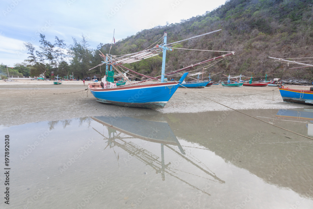 Wooden fishing boat on the  low tide beach.