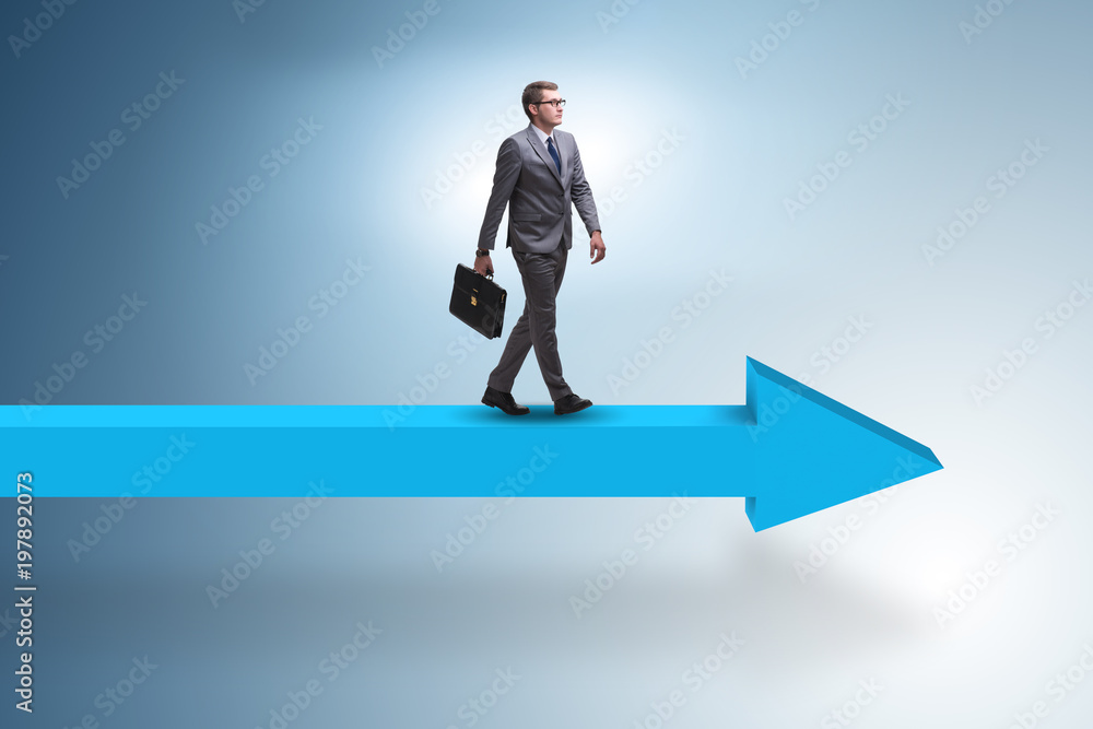 Fototapeta premium Businessman walking on arrow in business concept