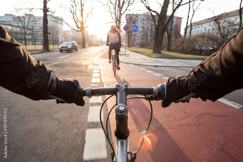 Fotografie First-person view of cyclist in the city at morning