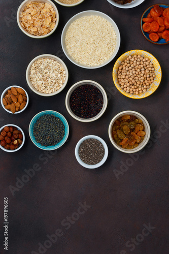 Top view set vegetarian healthy food - different superfood, seeds and cereal on dark background with copy space. Flat lay. Clean eating concept