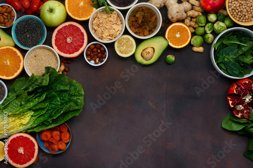 Flat lay clean eating concept. Set vegetarian healthy food - different vegetables and fruits, superfood, seeds, cereal, leaf vegetable on dark background with copy space, top view
