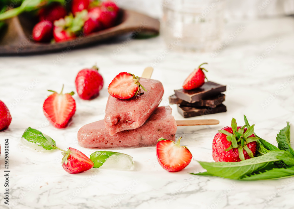 Strawberry ice cream with a banana and chocolate on a stick. Summer fresh dessert. Mint. Detox diet and summer food concept.Selective focus. Strawberry ice cream with a banana and chocolate on a stick. Summer fresh dessert. Mint. Detox diet and summer food concept.Selective focus.