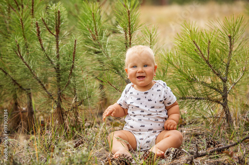 Portrait of a baby boy in green pine forest
