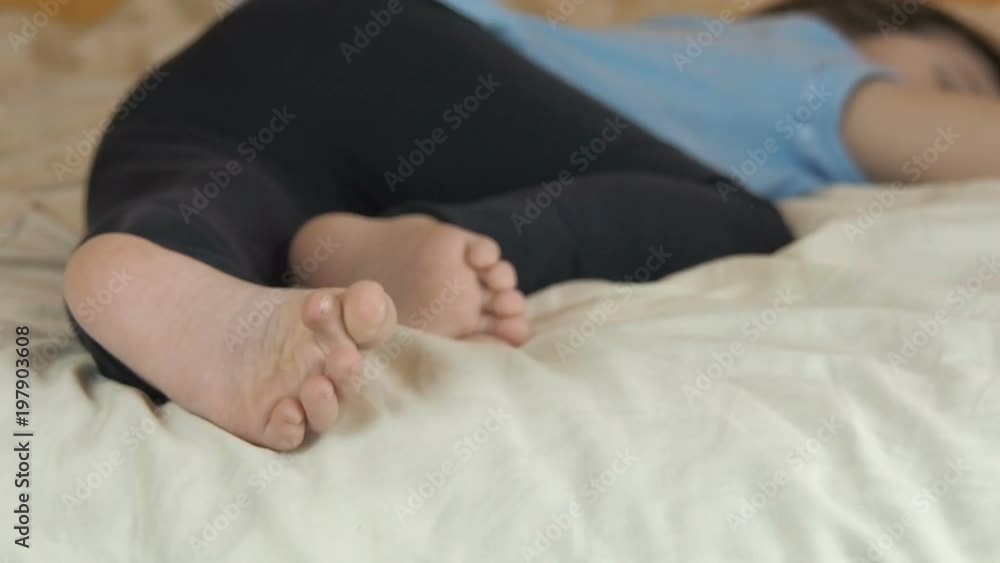 Feet of a child in bed. The little girl fell asleep on the bed. Feet of a child in bed. The little girl fell asleep on the bed.