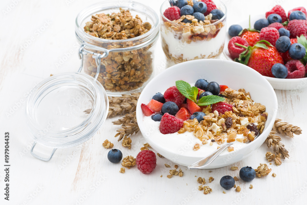healthy breakfast with natural yogurt, muesli and berries on white wooden background, closeup healthy breakfast with natural yogurt, muesli and berries on white wooden background, closeup