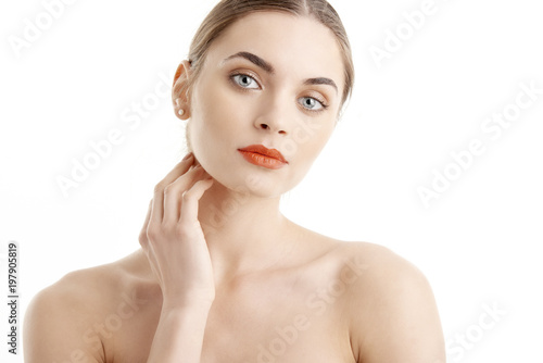 Close-up of beautiful young woman with red lips looking at camera while posing at isolated white background. Beauty shot in studio.