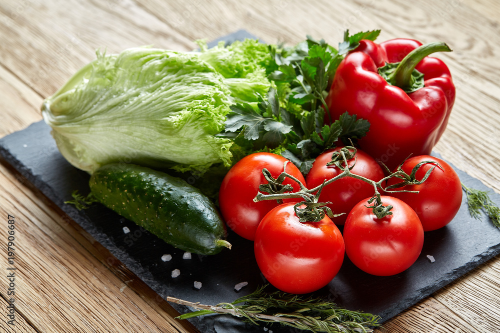 Close-up still life of assorted fresh vegetables and herbs on wooden rustic background, top view, selective focus.