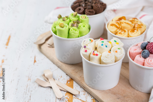 Selection of different rolled ice creams in cone cups